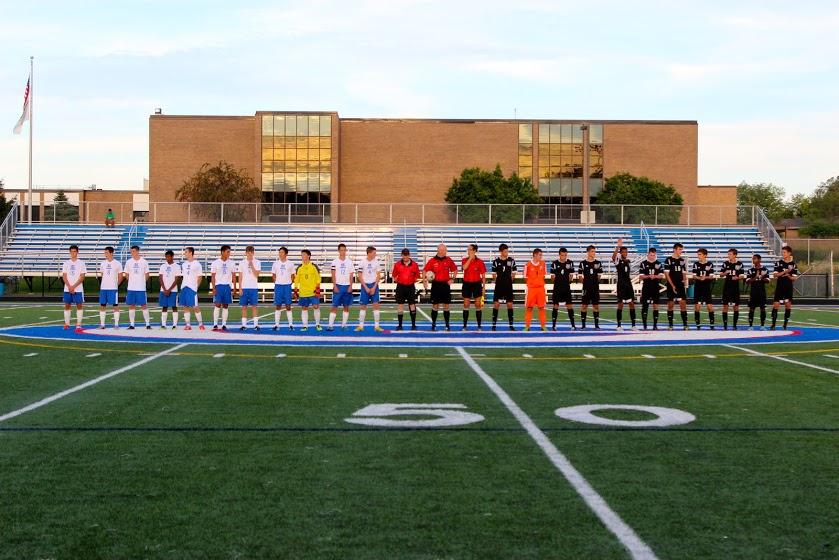 The varsity boys soccer team lines up with Wheaton Academy before the game.