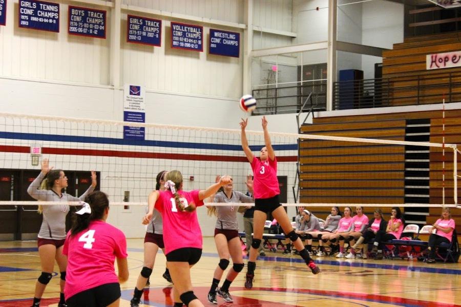 Sophomore Claire Werner sets up junior Makena Sweeton for a spike against rival Wheaton Academy. 
