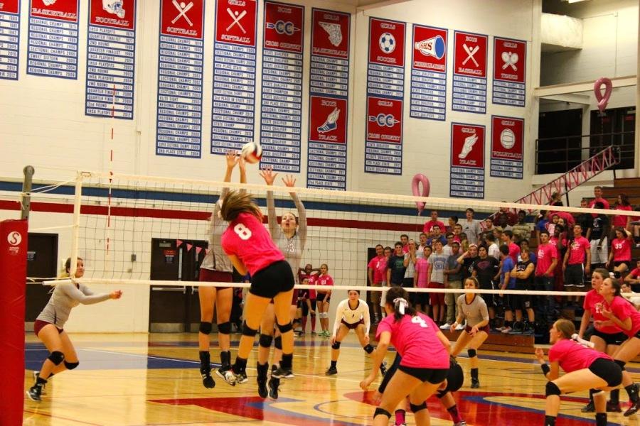 Junior Mackenzie Waterson goes up for a spike as the South student section cheers her on. 