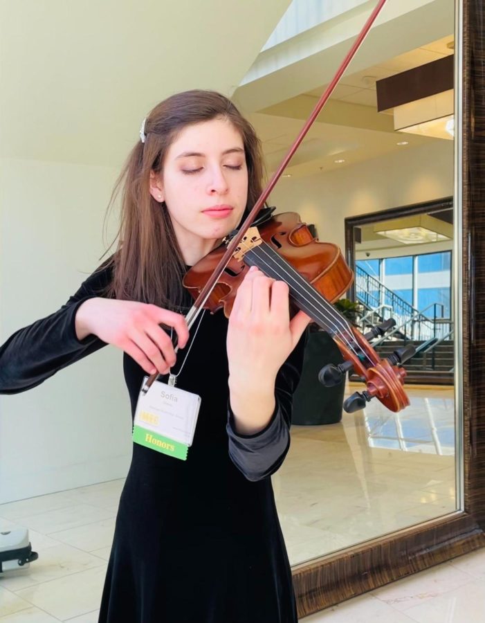 Grimes warming up before a performance with the ILMEA All-State Honors Orchestra. Source: Sofia Grimes