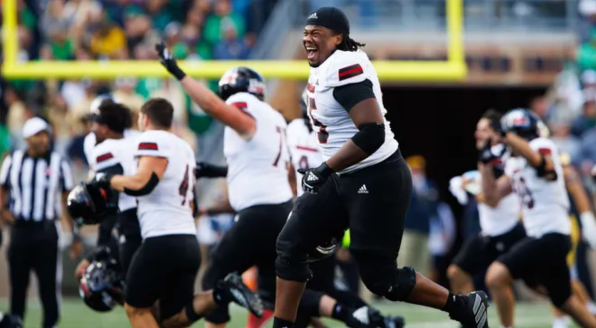 Huskie players rush off the field to celebrate the victory (Source: USA Today)