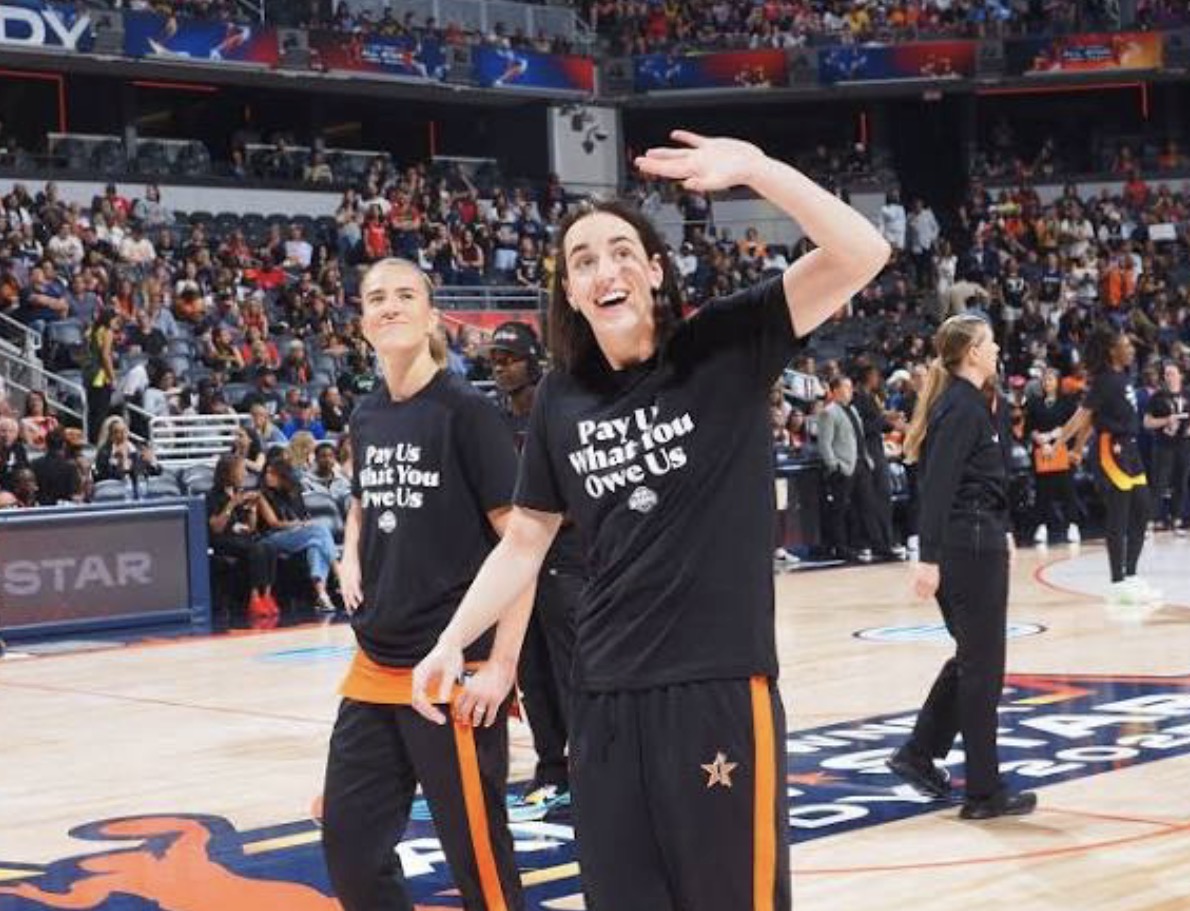 Sabrina Ionescu and Caitlin Clark wearing “Pay Us What You Owe Us” t-shirts. (Source: Getty Images)


